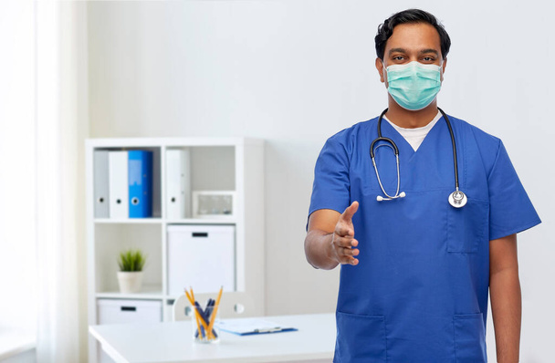 indian male doctor in blue uniform and mask - 写真・画像