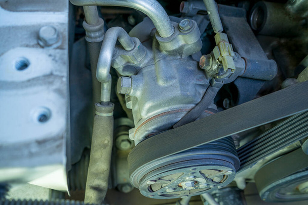 detail van het motorfragment: ac compressor riem en katrol. - Foto, afbeelding