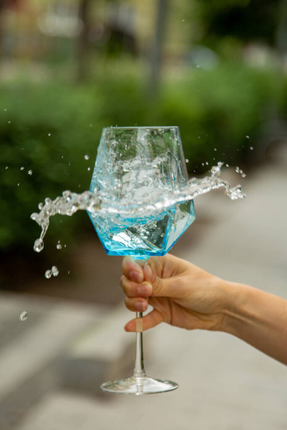 Блакитна вода виливається у винне скло - Фото, зображення