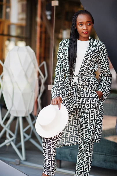 Beautiful african american woman natural makeup wear fashion clothes casual black and white dress code office style total blouse and pants suit and hat. - Foto, Imagem
