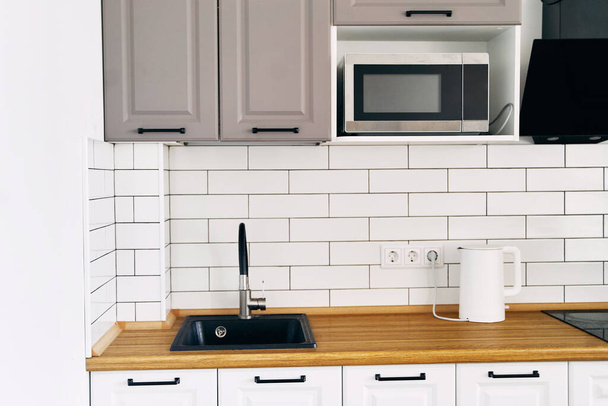 Белые шкафы с деревянными прилавками современной кухни. Высокое качество фото - Фото, изображение