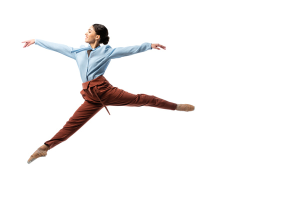 Vista lateral de la alegre bailarina saltando aislada en blanco  - Foto, imagen