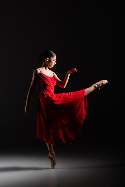 Vue latérale de la ballerine dansant sur fond noir - Photo, image