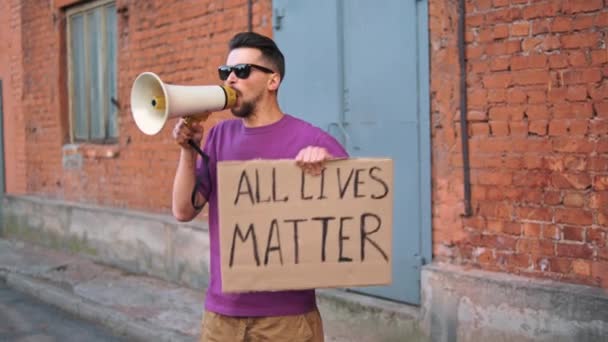 Caucasian man are protesting in the street with megaphones and signs - Footage, Video