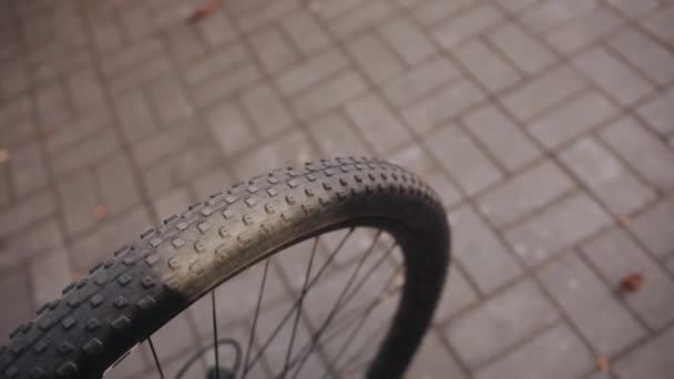 Primer plano de una parte de una rueda de bicicleta deportiva en una pista de baldosas de la ciudad en un día soleado - Imágenes, Vídeo