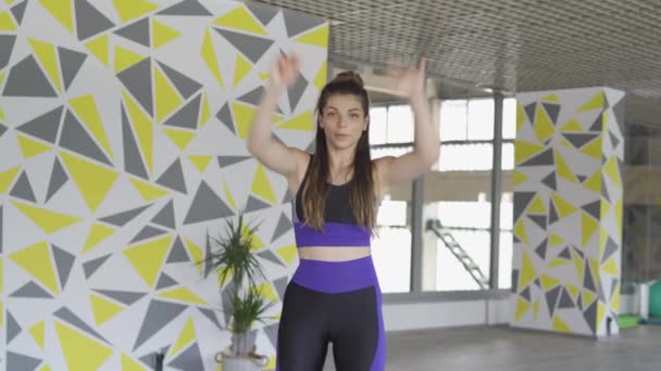 Female tabata trainer stretching arms with a big positive smile - Filmmaterial, Video