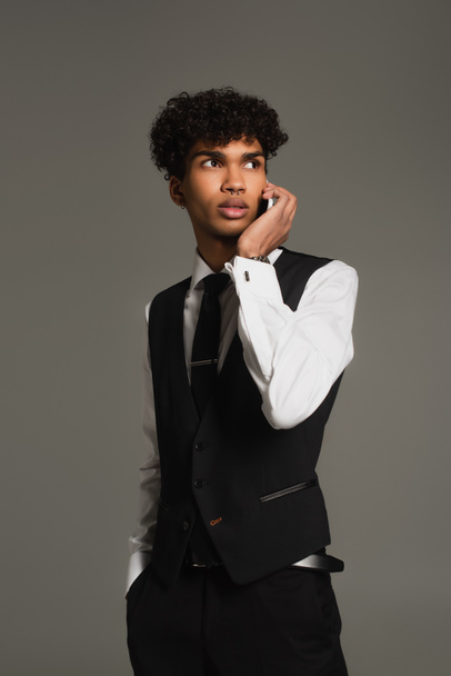 african american man in formal wear looking away while calling on smartphone isolated on grey - 写真・画像