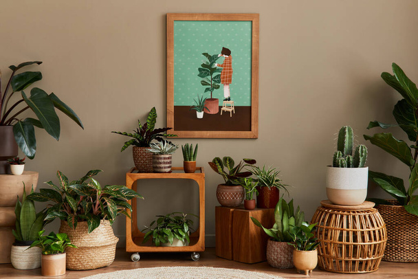 Stylish botany composition of home garden interior with wooden mock up poster frame, filled a lot of beautiful house plants, cacti, succulents in different design pots and floral accessories. Template - Photo, image