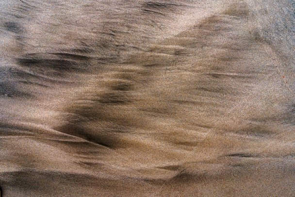 Полосатый песок на Калифорнийском пляже. Золотой песок с примесью черного песка. Шаблон на песке от ветра - Фото, изображение