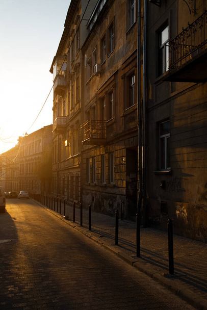 вертикальная картина улица пешком между старыми зданиями без людей здесь осенью золотой сезон время в конце сентября с вечерним солнечным светом и блики - Фото, изображение
