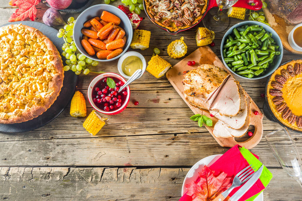 Kiitospäivän perheillallinen. Perinteinen kiitospäivän ruoka kalkkunan, vihreiden papujen ja perunamuusien kanssa, täyte, kurpitsa, omena- ja pekaanipiirakat, maalaismainen puinen pöytä - Valokuva, kuva
