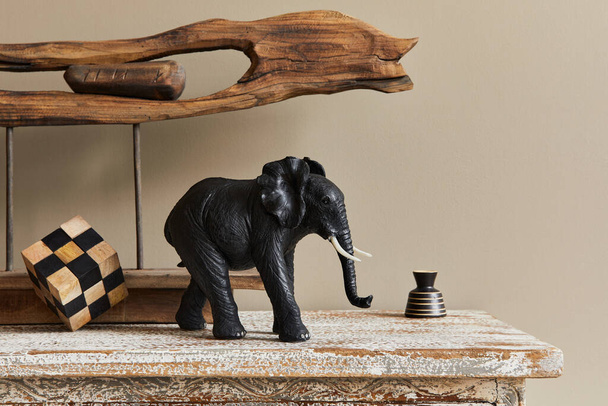 Stylish composition at moroccan interior with wooden shlef, cube, design elephant figure and decoration in modern home decor. Details. Template. - 写真・画像
