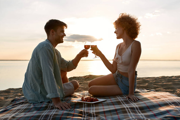 Smiling young caucasian couple drinking red wine - Photo, image