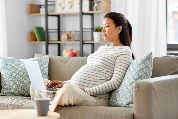 pregnant asian woman with laptop at home - Foto, Imagem