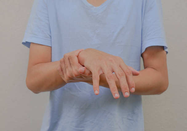 ένας άνθρωπος υποστηρίζει τα χέρια του τα οποία πόνο, μούδιασμα, αδυναμία, παράλυση έννοια του συνδρόμου Guillain barre που προκαλείται από αυτοάνοση διαταραχή                                                       - Φωτογραφία, εικόνα