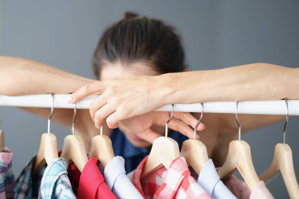 Mujer frustrada no puede elegir la ropa en el armario - Foto, Imagen