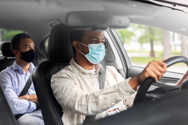 male driver in mask driving car with passenger - Foto, Imagem