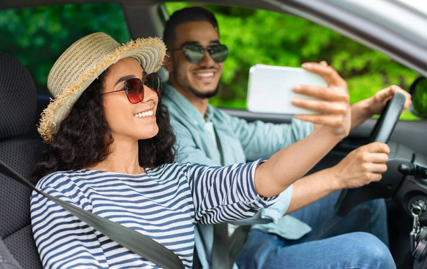 Belle jeune couple prenant selfie à l'intérieur de la voiture - Photo, image