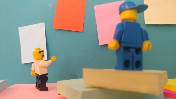 Dwóch mężczyzn Lego stojących przy ścianie z karteczkami - Zdjęcie, obraz