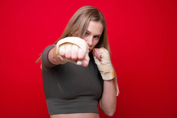 Atletische vrouwelijke bokser op rode achtergrond - Foto, afbeelding