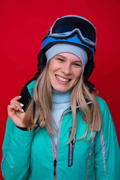 Πορτρέτο μιας χαμογελαστής νεαρής γυναίκας με μπουφάν, κράνος και γυαλιά του σκι - Φωτογραφία, εικόνα