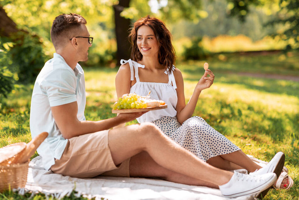 happy couple having picnic at summer park - 写真・画像