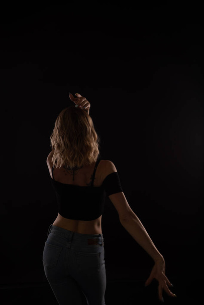 silhouette of the back of a dancing blonde woman - Фото, изображение