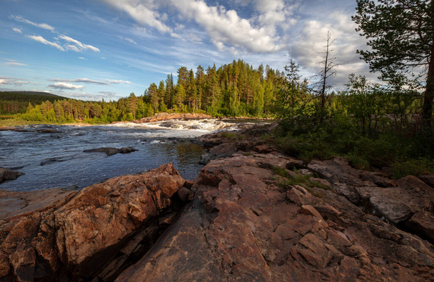 Polar Sweden. Rocky shore and fast mountain river under blue summer sky - Фото, изображение