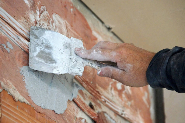 mano masculina con paleta enlucido pared de ladrillo primer plano - Foto, imagen