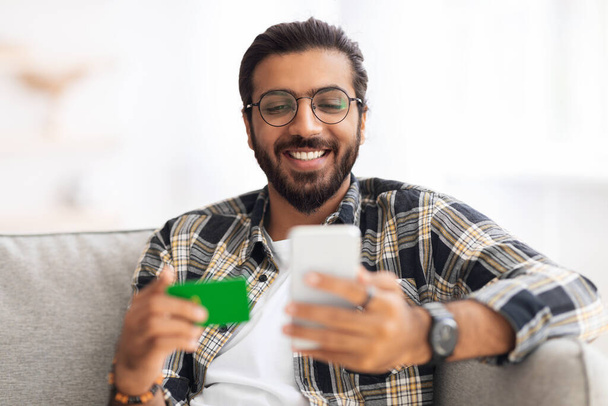 Veselý arabský muž s kreditní kartou a mobilem - Fotografie, Obrázek