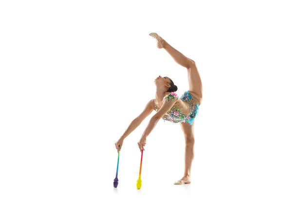 Uma ginasta rítmica feminina com clubes em movimento e ação isolada no fundo branco. - Foto, Imagem