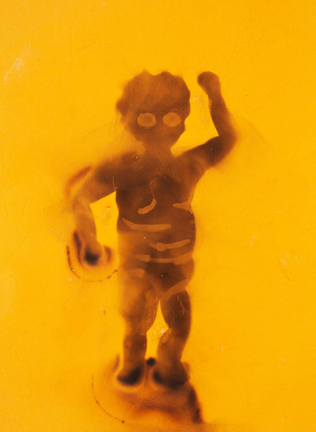 A little black african boy threatening with his little fist, hand drawn with smoke of a candle as symbol of suffering and dead African American people. Black Lives Matter concept in Fumage technique. - Фото, изображение