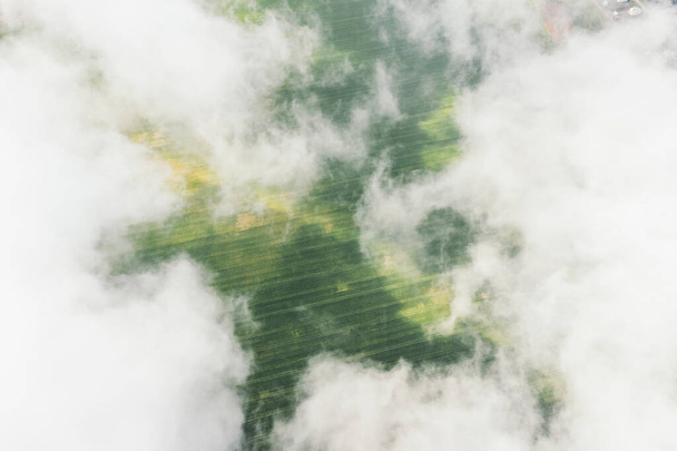 Високий політ у кумульських хмарах над сільськогосподарськими полями влітку. Вище за хмари
 - Фото, зображення