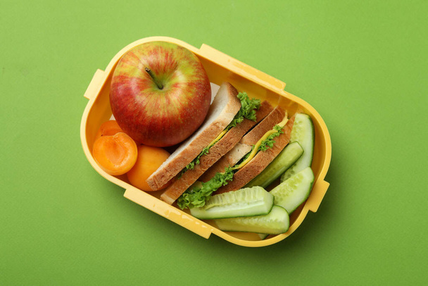 緑色の背景においしい食べ物を持つ弁当箱 - 写真・画像