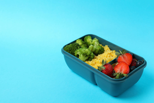 Caja de almuerzo con sabrosa comida sobre fondo azul - Foto, imagen