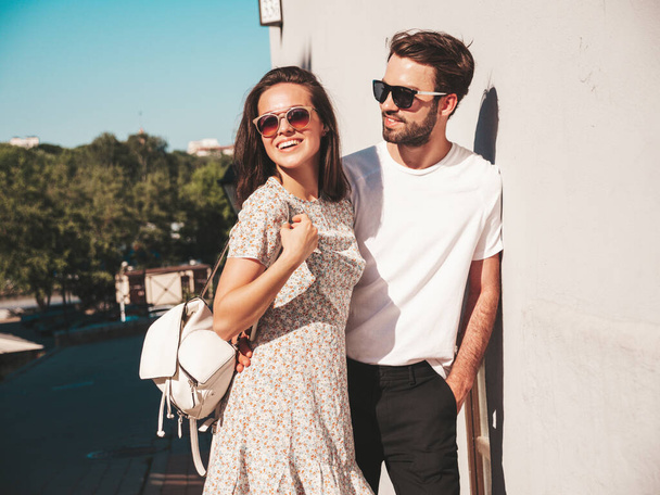 Portrait of smiling beautiful woman and her handsome boyfriend. Woman in casual summer clothes. Happy cheerful family. Female having fun. Couple posing on the street background in sunglasses - Foto, Imagem