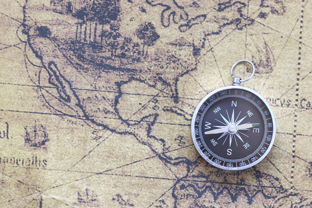 Klassischer runder Kompass auf dem Hintergrund einer alten historischen Weltkarte als Symbol des Tourismus mit Kompass, Reisen mit Kompass und Outdoor-Aktivitäten mit Kompass - Foto, Bild