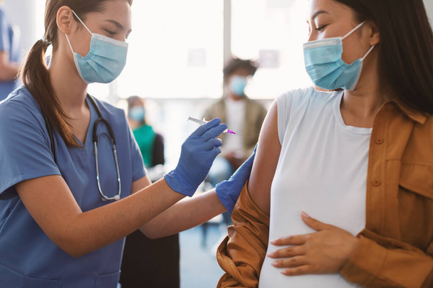 Doctor Making Coronavirus Vaccine Injection To Pregnant Woman In Hospital - Φωτογραφία, εικόνα