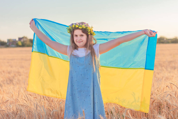 cute girl holding a blue and yellow flag of Ukraine. concept of national Ukrainian holidays. - Foto, imagen