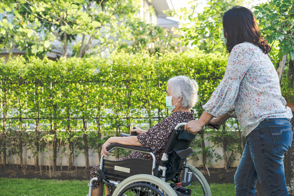 Lékařská pomoc a péče Asijské starší nebo starší žena pacient sedí na invalidním vozíku v parku v ošetřovně oddělení, zdravé silné lékařské koncepce. - Fotografie, Obrázek