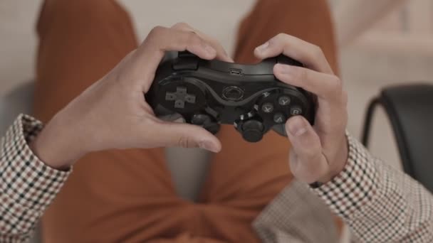 Vista superior de las manos de una persona irreconocible recortada usando el controlador de la consola de juegos, presionando botones - Metraje, vídeo