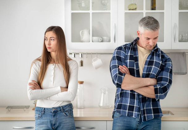Sértett érett házaspár áll a konyhában keresztbe tett karral veszekedés után otthon - Fotó, kép