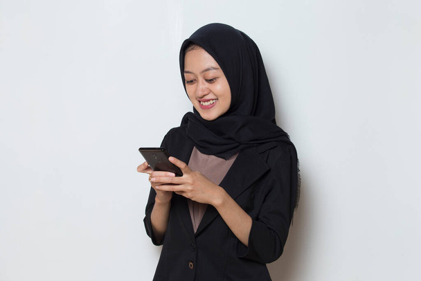 счастливая молодая азиатская мусульманка бизнес-женщина с помощью мобильного телефона - Фото, изображение