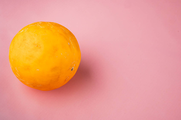 Set entero de melón maduro amarillo, sobre fondo de verano texturizado rosa, con espacio de copia para texto - Foto, imagen