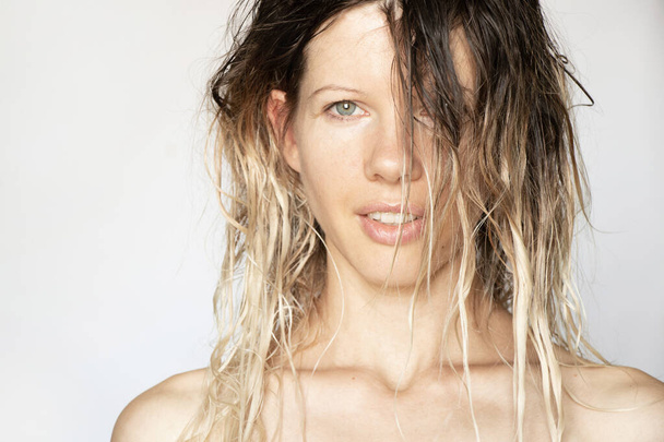 retrato de una joven sobre un fondo blanco con el pelo largo mojado, cara de niña, modelo, cabeza - Foto, imagen