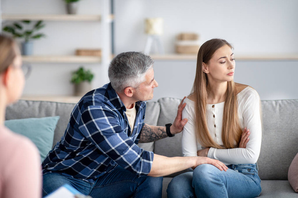 Mature married man supporting his depressed wife on consultation with psychologist at office. Family therapy concept - Photo, Image