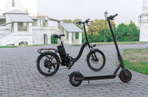 Електричний велосипед і електричний скутер на тлі старовинної будівлі
. - Фото, зображення