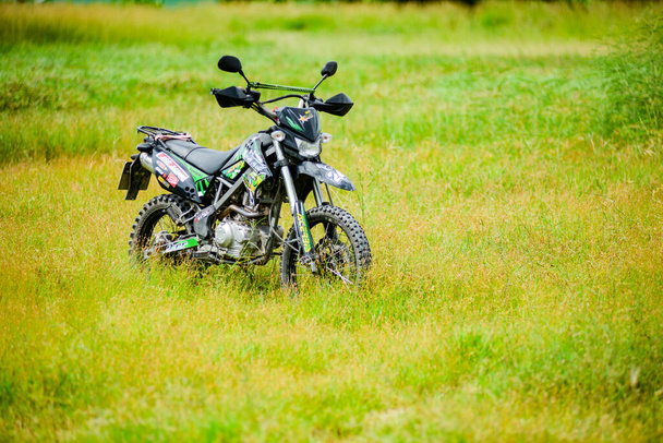 Kawasaki motocross motorcycle parked in a field on July 21, 2021, Surat Thani, Thailand. - Photo, Image