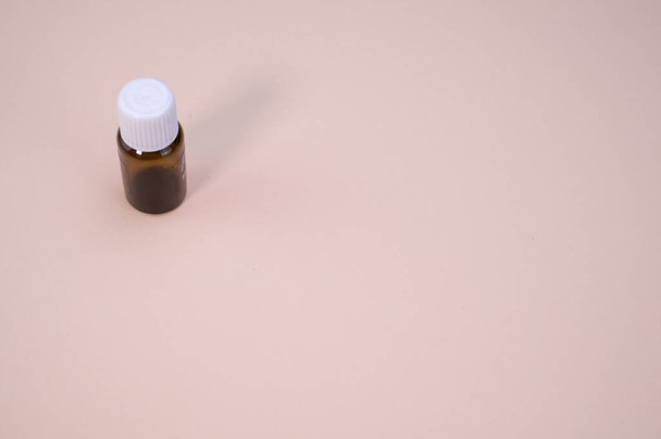 A small vial isolated on a beige background - Valokuva, kuva