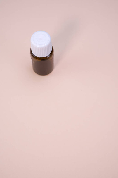 A small vial isolated on a beige background - Valokuva, kuva